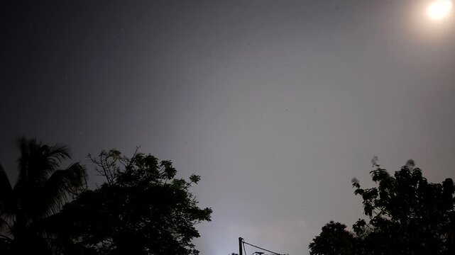 Daybreak timelapse of starry night sky and moving clouds transitioning into bright morning dawn