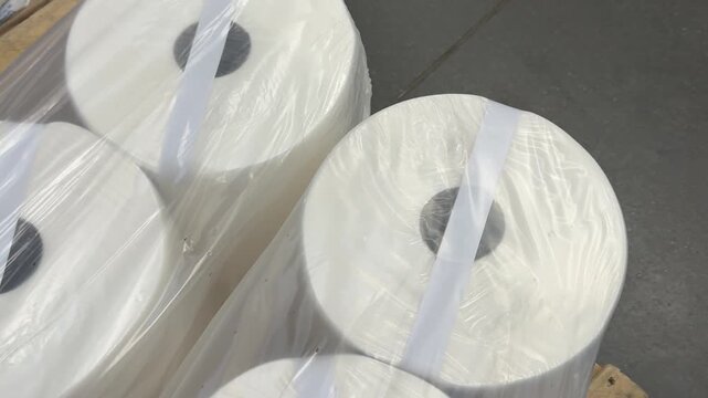 Household paper towels are stacked in sealed packages, creating an organized retail display that offers convenient access to everyday cleaning and kitchen essentials. Close up.