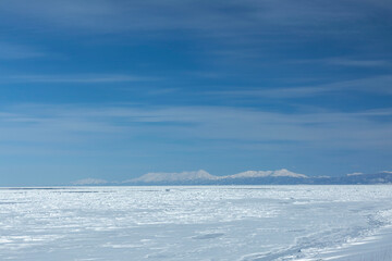 Pristine winter seascape with drifting ice floes and snow-capped mountains along Hokkaido's Okhotsk Sea coast © kei u