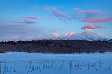 Frozen sea ice and snow-capped mountains reflecting winter dawn light in Hokkaido, Japan © kei u