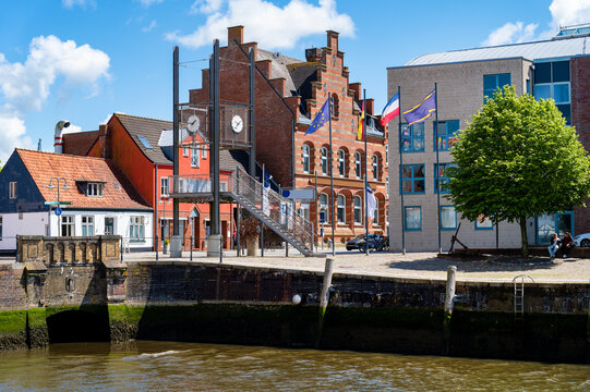 View of Husum's harbor promenade with the observation tower, historic brick buildings and the inner harbor on a sunny summer day.