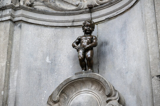 Close view of the iconic Manneken Pis bronze statue in Brussels, showcasing one of Belgium's best-known landmarks surrounded by the historic charm of the city center.