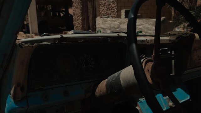 Interior of an abandoned vintage vehicle with weathered cabin overlooking rugged desert landscape symbolizing passage of time forgotten places resilience isolation and harsh environment