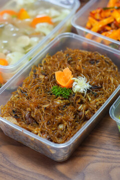 Close up of fried rice vermicelli bihun goreng in plastic container with garnish. Asian homemade noodle dish for takeaway meal prep catering and street food concept.