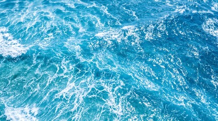 Fototapeta premium Aerial view of deep blue ocean waves with white sea foam splashing in sunlight