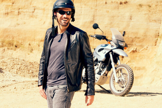 Mature man with motor bike in sand pit