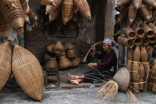 Artisan weaving bamboo fish trap in rural Hanoi workshop