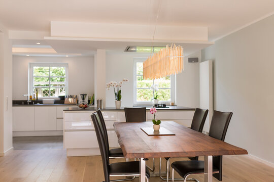 Modern dining area with open plan kitchen in the background
