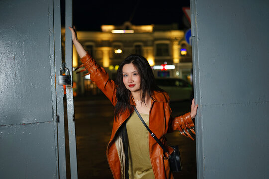 Woman opening iron gates in the city on a summer evening