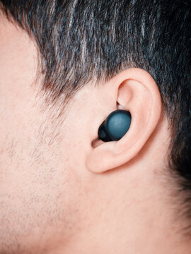 Person listening to music using wireless earbud technology