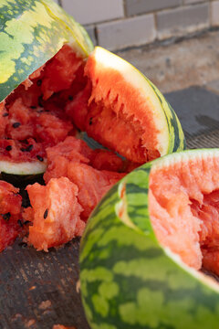 Broken ripe watermelons with chunks of red flesh and black seeds