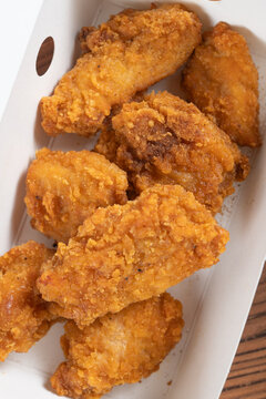 Crispy salt pepper fried chicken pieces placed inside a white paper takeaway box