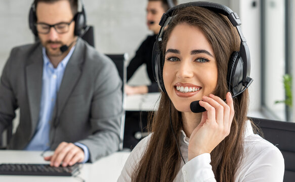 Close up portrait of a happy young female call center operator talking on a headset