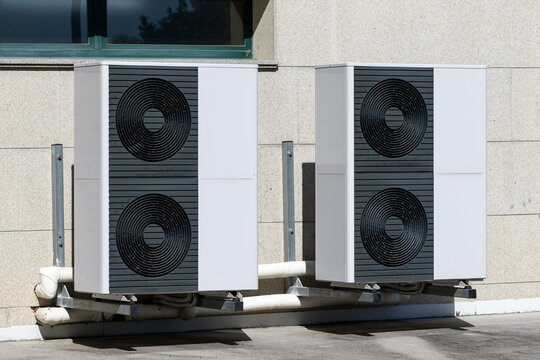 Two big Air conditioner compressor units installed outside of a building