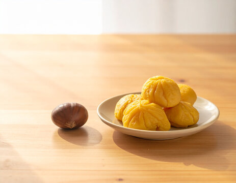 Japanese kurikinton chestnut sweets with a fresh chestnut on a wooden table