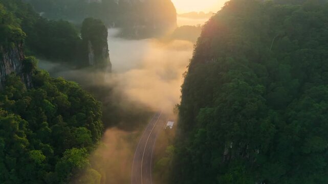 Aerial view of a scenic road through limestone karst mountains and morning mist in Krabi, Thailand