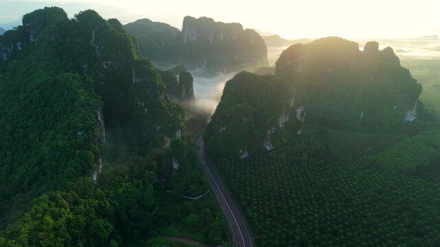 Aerial view of a scenic road through limestone karst mountains and morning mist in Krabi, Thailand