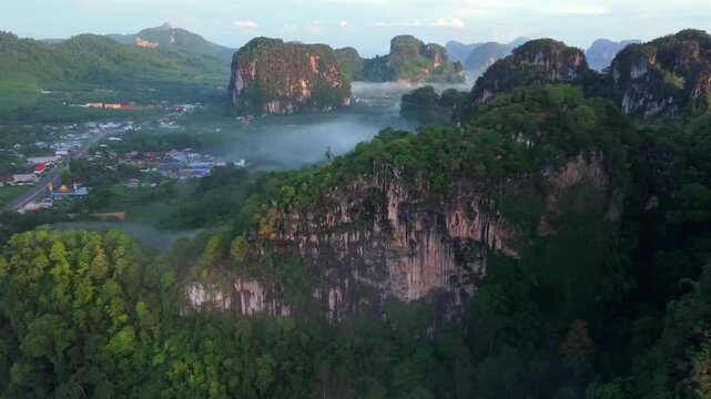 Aerial view of a scenic road through limestone karst mountains and morning mist in Krabi, Thailand