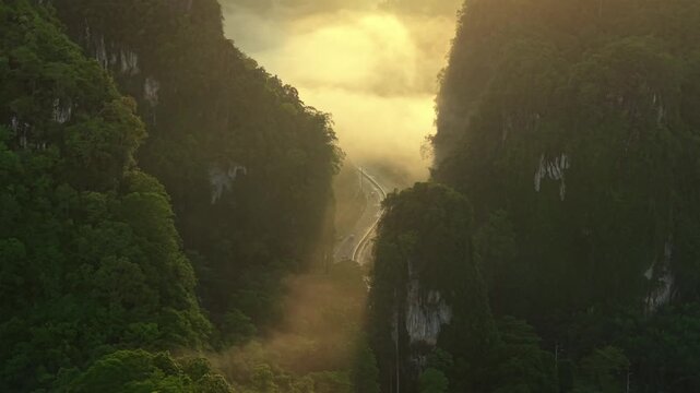Aerial view of a scenic road through limestone karst mountains and morning mist in Krabi, Thailand