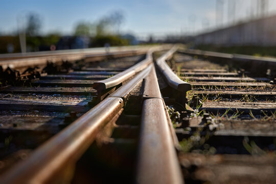 Close-up of railway track switch with shallow depth of field, rusty rail junction low angle macro view