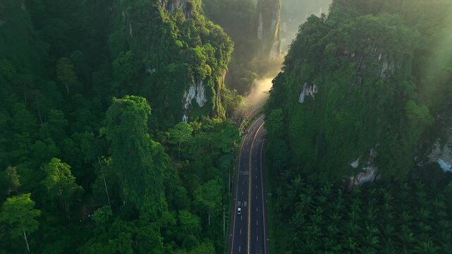 Aerial view of a scenic road through limestone karst mountains and morning mist in Krabi, Thailand