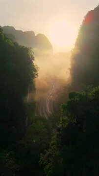 Aerial view of a scenic road through limestone karst mountains and morning mist in Krabi, Thailand