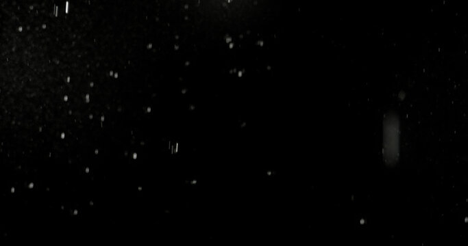 Realistic rain streaks isolated on a black background creating a realistic weather overlay with dynamic falling droplets perfect for visual effects compositing graphic design.