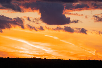 Fototapeta premium Sunset over a landscape with clouds in the sky and light reflecting on the horizon