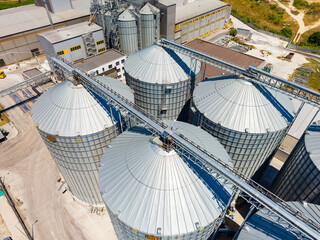 Large storage silos at a grain facility seen from above during the day with clear skies and surrounding landscape visible © DSMT