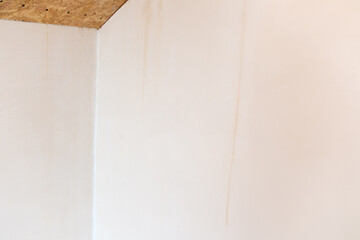 Interior wall corner with subtle stains and wood ceiling © reddish