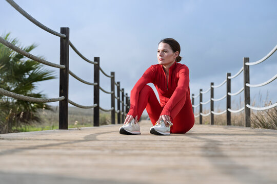 sporty woman runner sitting resting, outdoors
