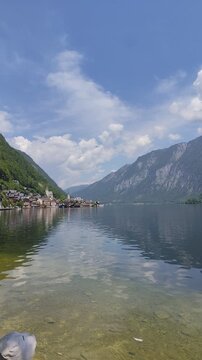 Hallstatt Village on a Mountain Lake water with Blue Sky and Clouds. Nature waves