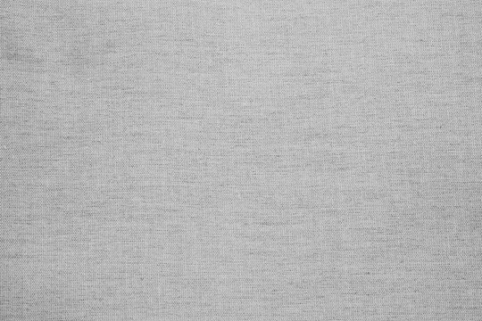 Close up of fine woven grey fabric surface with visible threads for background use