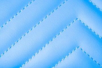 Obraz premium Smooth light blue quilted leather material background with elegant white diagonal stitching detail