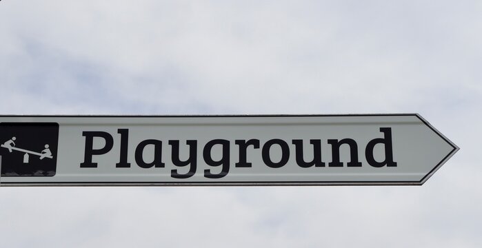 A close view of the brown and white playground sign.