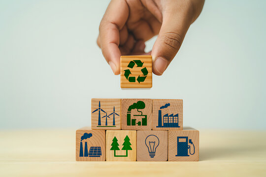 Hand holding wooden block with recycling