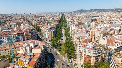 Obraz premium Aerial view of central Barcelona featuring the historic bullring, wide boulevards, modern cityscape and the Mediterranean Sea on a sunny summer day.