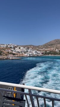 Waves of ship leaving the port of Donousa island during a sunny summer day