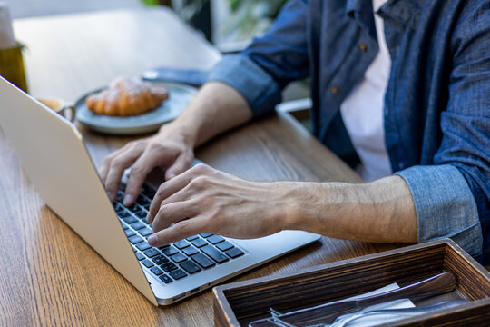 Close up of makes hands typing on a laptop