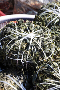 Bundles of dried greens tightly bound with white string. in a market in South Korea