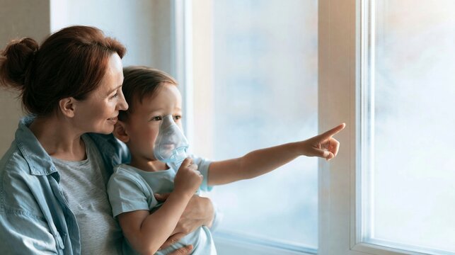 Mother providing care to young boy with nebulizer for respiratory treatment, child pointing with interest from home window