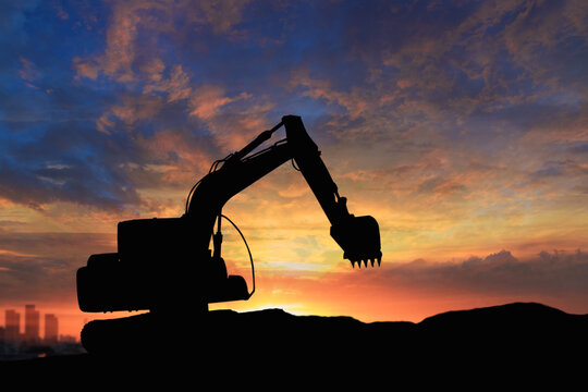Crawler excavator silhouette digging the soil  ,In the construction site on sunset background