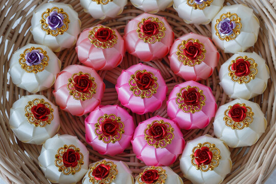 Handmade craft Thai festival decoration,Coins wrapped in floral ribbons on a basket against   background.