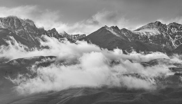 Black and white landscape, mountain peaks in the clouds, summer travels