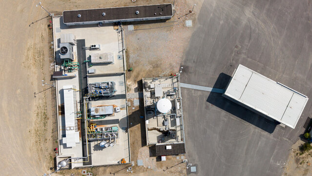 Aerial view of an LNG and CNG fueling facility with industrial equipment, storage tanks, and paved areas in Lodi, Lombardy, Italy.
