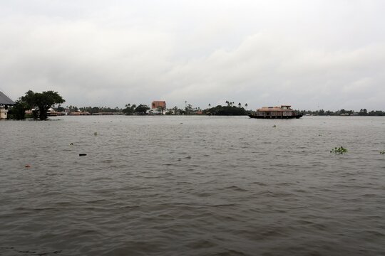 Ferry tour in a lake in Keralam, India on an overcast day, visiting coconut-tree islands.
