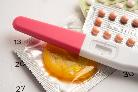 Pregnancy test and birth control pills on calendar, contraception health and medicine.