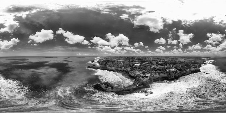 Drone spherical view of Pura Batu Bolong with ocean, cliffs, and temple architecture in black and white