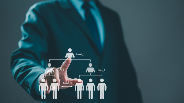 Businessman touching virtual organizational chart representing business hierarchy levels, managing human resources team structure inside dark office workspace, planning career progression pathways.