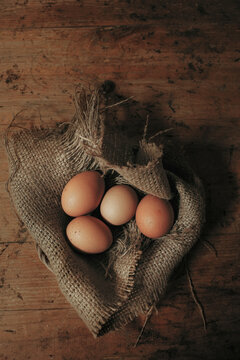 Organic Farm Eggs on Burlap Cloth with Rustic Wooden Background